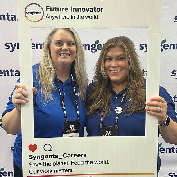 Kaci Rice, emerging talent program manager for Syngenta, at a networking event holding a decorative frame to promote Syngenta socials