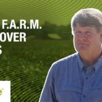 A photo of a Mississippi grower with the fields of cover crops at Delta F.A.R.M. in the background